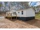 Single-story home with fresh white exterior paint and a wooden deck, set on a natural lot at 75 Woodfield Rd, Covington, GA 30014
