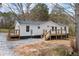 Charming single-story home with a freshly painted exterior, a wooden deck, and a gravel driveway at 75 Woodfield Rd, Covington, GA 30014