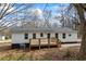 Well-kept home showcasing fresh white paint, a wooden deck, and natural surroundings at 75 Woodfield Rd, Covington, GA 30014