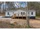 Charming house showcasing a fresh white exterior, wooden deck, and natural surroundings at 75 Woodfield Rd, Covington, GA 30014