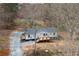 Quaint single-story home featuring a wooden deck and gravel driveway surrounded by trees at 75 Woodfield Rd, Covington, GA 30014