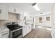 Modern kitchen with white cabinets, stainless steel appliances, and new flooring at 75 Woodfield Rd, Covington, GA 30014