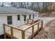 View of the home's rear deck with metal railing and white siding at 75 Woodfield Rd, Covington, GA 30014