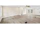 Bright open-concept living area with a ceiling fan, two windows, and light wood-look flooring at 75 Woodfield Rd, Covington, GA 30014