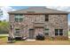 View of the home's brick exterior, backyard patio, and outdoor seating area at 104 Amelia Way, Ellenwood, GA 30294