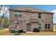 View of the home's brick exterior, backyard patio, and outdoor seating area at 104 Amelia Way, Ellenwood, GA 30294