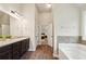 Bright bathroom with a granite countertop vanity, tub, and an open doorway to the main bedroom at 104 Amelia Way, Ellenwood, GA 30294