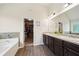 Elegant bathroom with double sinks, a bathtub, and a large walk-in closet at 104 Amelia Way, Ellenwood, GA 30294