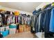 Walk-in closet with clothes, bags, home depot boxes, and plastic bins on carpeted floor at 104 Amelia Way, Ellenwood, GA 30294