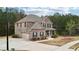 Two-story brick home with a large driveway, attached garage, and well-maintained landscaping at 104 Amelia Way, Ellenwood, GA 30294