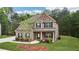 Charming brick home with lush green lawn, tree accents and inviting front porch with lovely curb appeal at 104 Amelia Way, Ellenwood, GA 30294