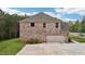 View of the brick home showing the attached two-car garage and well-maintained landscaping at 104 Amelia Way, Ellenwood, GA 30294