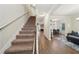 Inviting home entryway with carpeted stairs, hardwood floors, and open access to dining and living spaces at 104 Amelia Way, Ellenwood, GA 30294