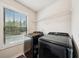 Laundry room with large window, shelving and modern black stainless steel washer and dryer at 104 Amelia Way, Ellenwood, GA 30294