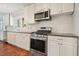 Bright kitchen featuring stainless appliances, white cabinetry, subway tile backsplash, and hardwood floors at 1495 Longwood Sw Dr, Marietta, GA 30008