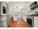 Open kitchen featuring stainless appliances, white cabinetry, an island, and hardwood floors at 1495 Longwood Sw Dr, Marietta, GA 30008