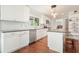 Bright kitchen featuring stainless appliances, white cabinetry, an island, and hardwood floors at 1495 Longwood Sw Dr, Marietta, GA 30008