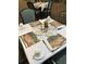 Nicely set dining table with placemats, plates, glasses, silverware, napkins and a lavender plant in the center at 1800 Clairmont Lk # A719, Decatur, GA 30033