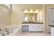 Luxurious bathroom featuring a jacuzzi tub, a vanity, and natural lighting at 2542 Ashridge Ct, Lawrenceville, GA 30043