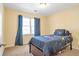 Neutrally decorated bedroom featuring a window with blue curtains and carpeted floors at 2542 Ashridge Ct, Lawrenceville, GA 30043