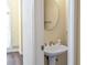 Powder room featuring pedestal sink and round mirror at 2542 Ashridge Ct, Lawrenceville, GA 30043