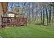 Manicured lawn in the backyard with a small deck area and forest backdrop at 2895 Wildflower Ln, Snellville, GA 30039