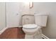 Half bath features a toilet with wood-look floor, sink and cabinet at 2895 Wildflower Ln, Snellville, GA 30039