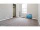 A sunlit bedroom with neutral walls, soft carpet, and a view of the outdoors at 2895 Wildflower Ln, Snellville, GA 30039