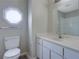 Bathroom featuring unique window above the toilet, alongside the vanity and a shower at 864 Oakhill Ct, Stone Mountain, GA 30088