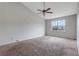 Bright bedroom featuring vaulted ceiling, ceiling fan, and a large window with a neighborhood view at 864 Oakhill Ct, Stone Mountain, GA 30088