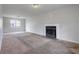 Spacious living room featuring a fireplace, large window, and neutral carpet flooring at 864 Oakhill Ct, Stone Mountain, GA 30088