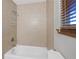 Clean white bathtub with tile surround and shower head at 4062 Wildflower Ln, Tucker, GA 30084