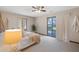 Cozy bedroom filled with natural light, plush carpeting, and a sliding door to the backyard at 4062 Wildflower Ln, Tucker, GA 30084