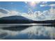 Scenic lake view under a sunny sky with white clouds and mountain views beyond the tree line at 4062 Wildflower Ln, Tucker, GA 30084
