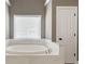 Bright bathroom featuring a soaking tub, marble surround and natural light at 2315 Monet Dr, Cumming, GA 30041