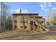 Back of the house with a wooden deck and stairs overlooking a grassy yard and woods at 2315 Monet Dr, Cumming, GA 30041