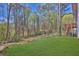 Serene backyard with mature trees, green lawn, and back of home at 3618 Mansfield Ln, Snellville, GA 30039