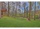 Lush green backyard with lawn, chain-link fencing, and trees at 3618 Mansfield Ln, Snellville, GA 30039