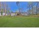 Expansive backyard featuring a lush green lawn, fence, and mature trees at 3618 Mansfield Ln, Snellville, GA 30039