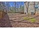 Backyard with a large, mostly bare area surrounded by trees and some green patches of grass at 585 Lake Dr, Snellville, GA 30039