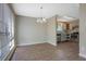 Open dining area features a modern chandelier, vinyl floors, and a view into the kitchen at 585 Lake Dr, Snellville, GA 30039