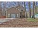 Two-story home featuring a front yard with mature trees and a well-maintained lawn on a sunny day at 585 Lake Dr, Snellville, GA 30039