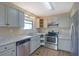 Updated kitchen with stainless steel appliances, light grey cabinets, and solid surface countertops at 585 Lake Dr, Snellville, GA 30039