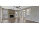 Open living room with a stone fireplace, wood mantle, neutral-toned walls and wood-look vinyl floors at 585 Lake Dr, Snellville, GA 30039
