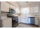 Bright kitchen features stainless steel appliances, white cabinets, and light countertops at 1202 W Briar Gate Ct, Riverdale, GA 30296
