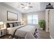 This staged primary bedroom features neutral colors, large window, and wood-look flooring at 1202 W Briar Gate Ct, Riverdale, GA 30296