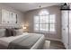 This staged primary bedroom features neutral colors, large window, and wood-look flooring at 1202 W Briar Gate Ct, Riverdale, GA 30296