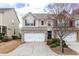 Charming townhome featuring a two-car garage and well-maintained landscaping at 1212 Lake Point Way, Suwanee, GA 30024