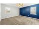 Spacious bedroom with a blue accent wall, carpet flooring, a ceiling fan, and two windows for natural light at 135 Tanyard Ct, Newborn, GA 30056