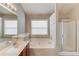 Bright bathroom features a large tub, separate shower, and a double sink at 1554 Park Grove Dr, Lawrenceville, GA 30046